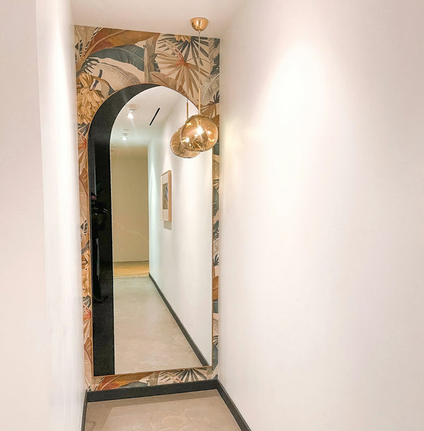 a hallway with a mirror and lights on the wall