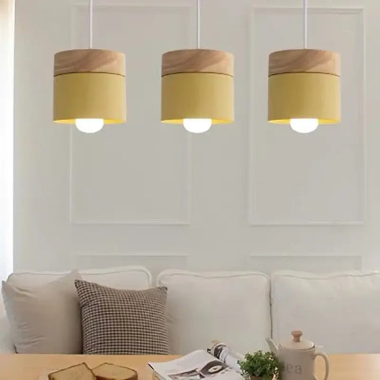 Simple Metal Danish Pendant with Wood in yellow hanging in a modern living space, providing stylish illumination.