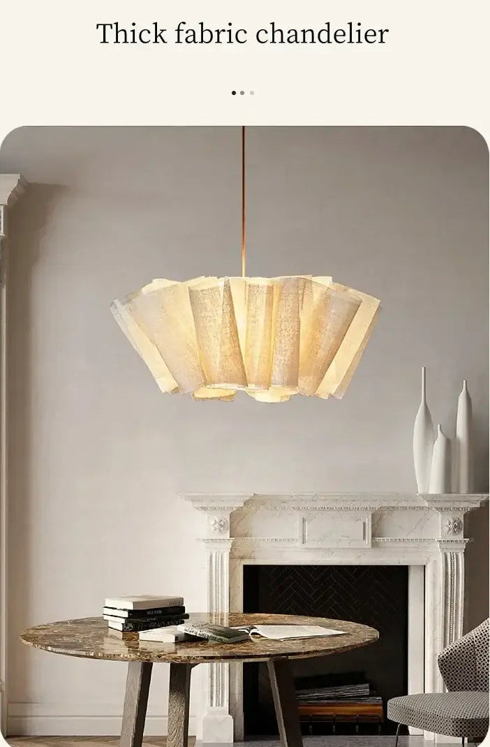 Fabric pleated Chandelier hanging above a stylish dining table in a modern Scandinavian setting.