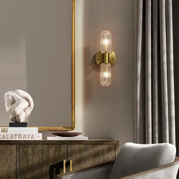 Radiant Luxe Gold Wall Sconce illuminating a chic indoor setting with glass and gold finish.