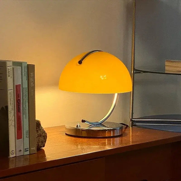 80s USB desk lamp in various colours with a yellow shade on a wooden desk.