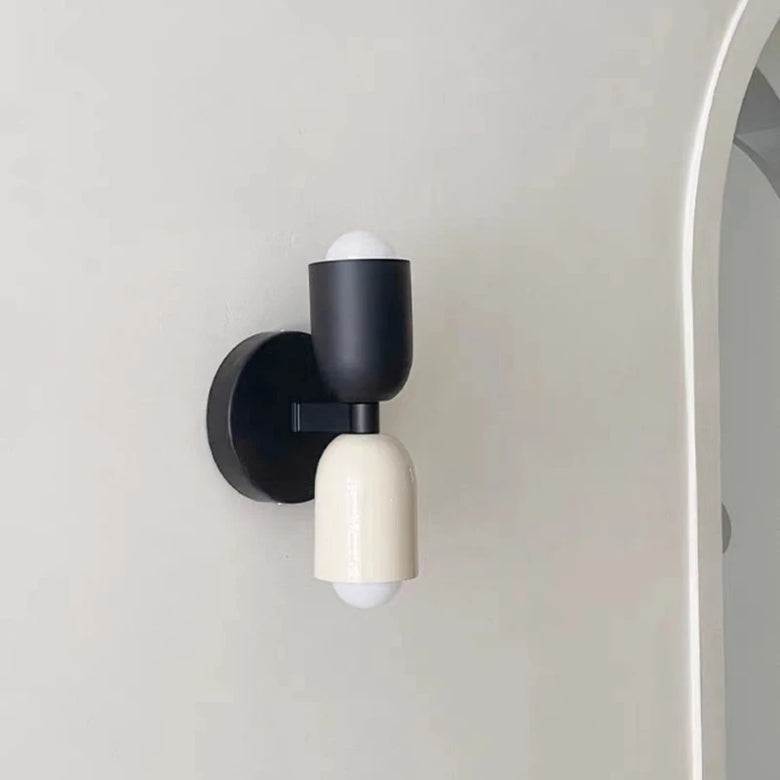 Modern wall light fixture with black and white design on a neutral background