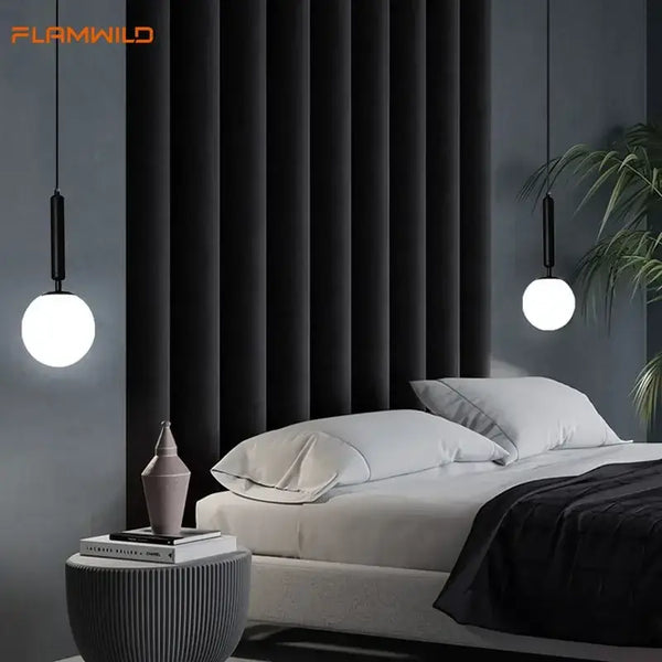 Mid-Century Modern Glass Ball Pendant Light hanging above a stylish bed in a contemporary bedroom setting.