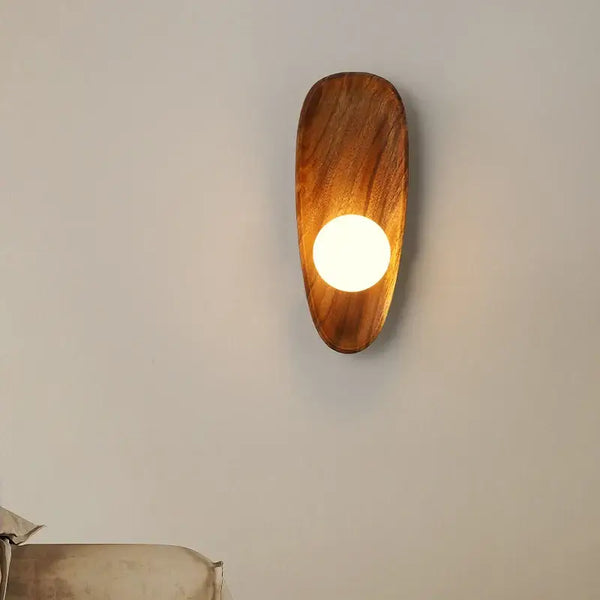 Vintage Walnut Wall Light mounted on a wall, featuring a round LED light and a sleek walnut wood design.