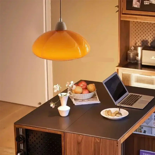 The Ideal Modern Kitchen Glass Pendant adds warmth with its unique pumpkin shape in orange, illuminating a stylish kitchen.