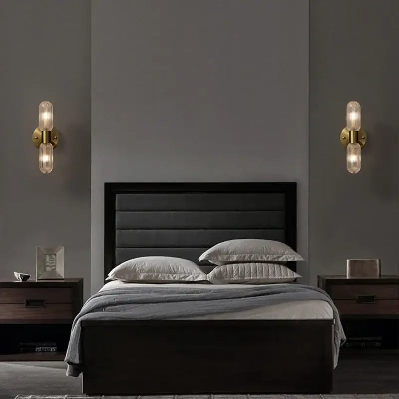 Radiant Luxe Gold Wall Sconce illuminating a modern bedroom with its sleek design and opulent gold finish