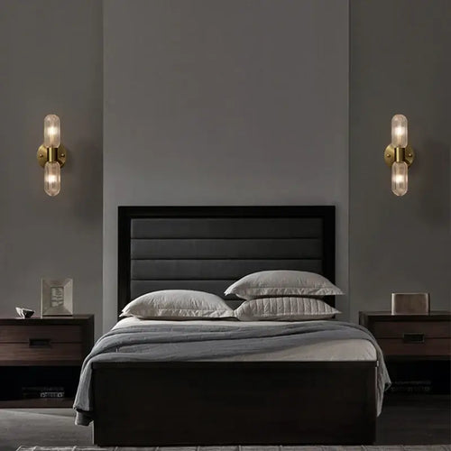 Radiant Luxe Gold Wall Sconce illuminating a modern bedroom with elegant design and warm lighting.