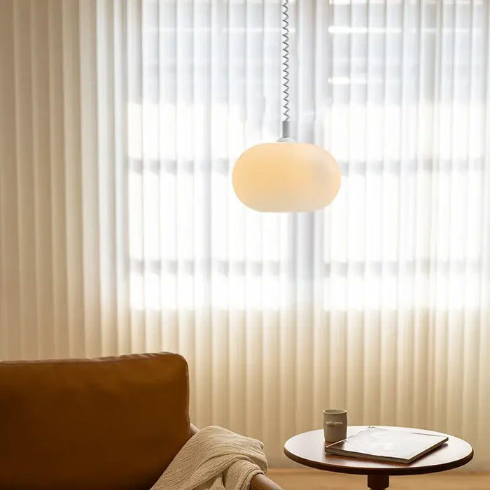 Bauhaus Glass Chandeliers with bright cord hanging in a bright room with sheer curtains.