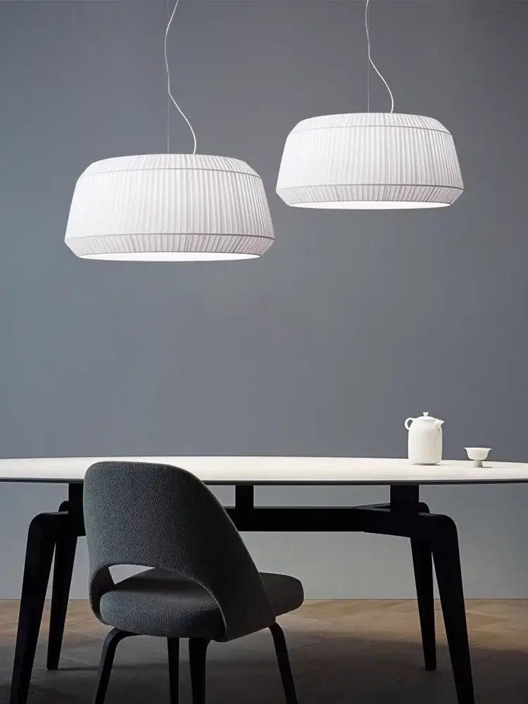 Nordic Pleated Fabric Pendant Light – Soft Minimalist Ceiling Lamp hanging above a modern dining table with a grey chair.