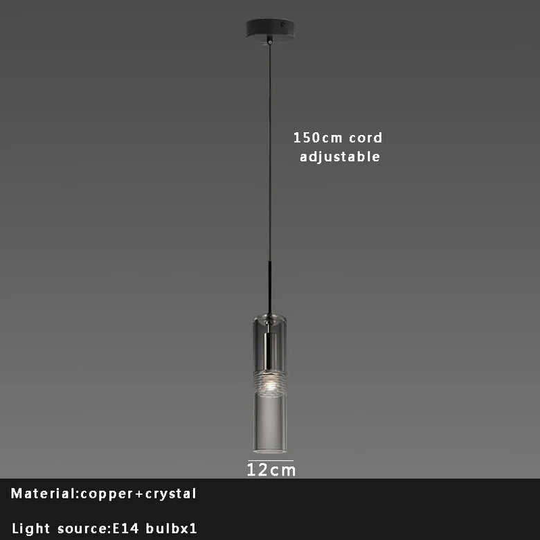 Pendant light with clear glass shade and adjustable cord on a dark background