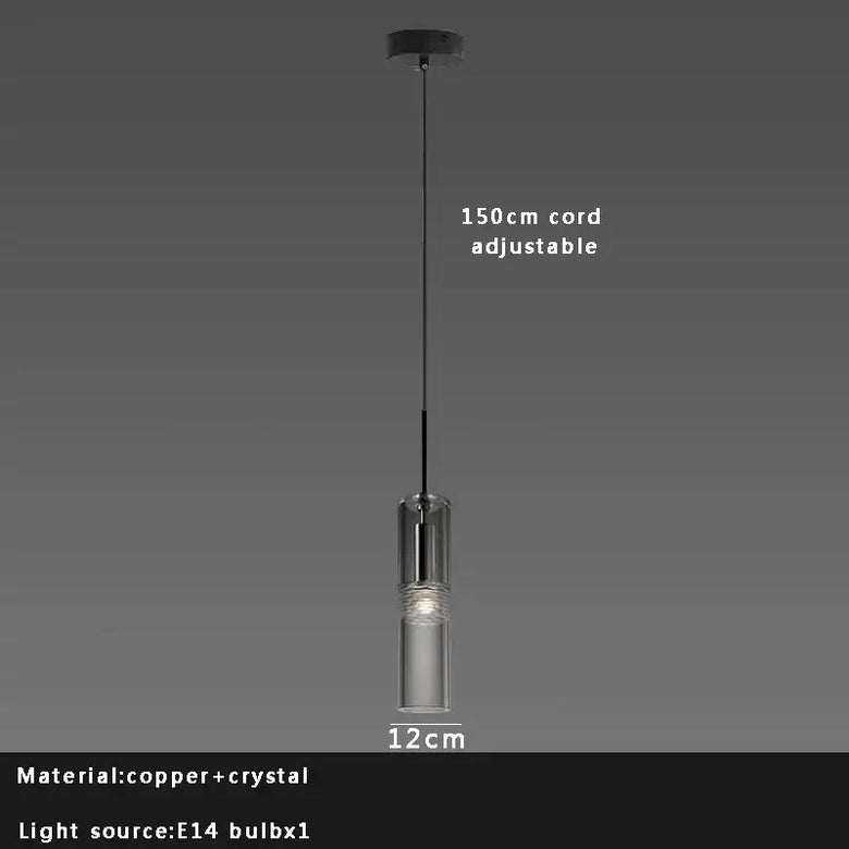 Pendant light with clear glass shade and adjustable cord on a dark background
