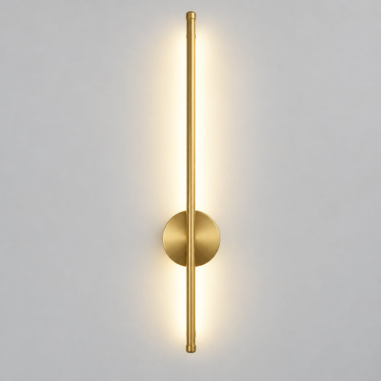 Hero Magnetic Wall Lamp / wall sconce light fixture in brushed gold/brass finish with a circular backplate and vertical light bar, shown lit on a light gray wall.