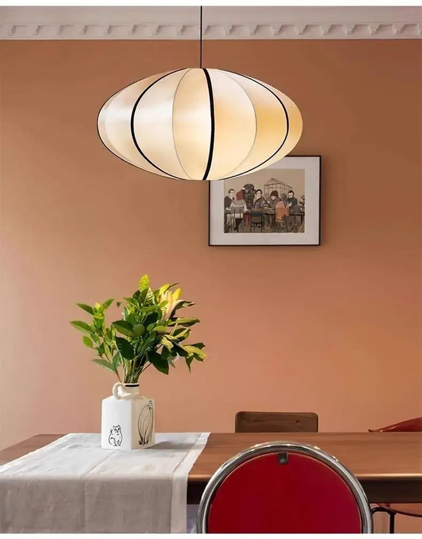Zen Silk Pendant Light Mid Century Fabric Lantern illuminating a dining room with warm, calming glow.