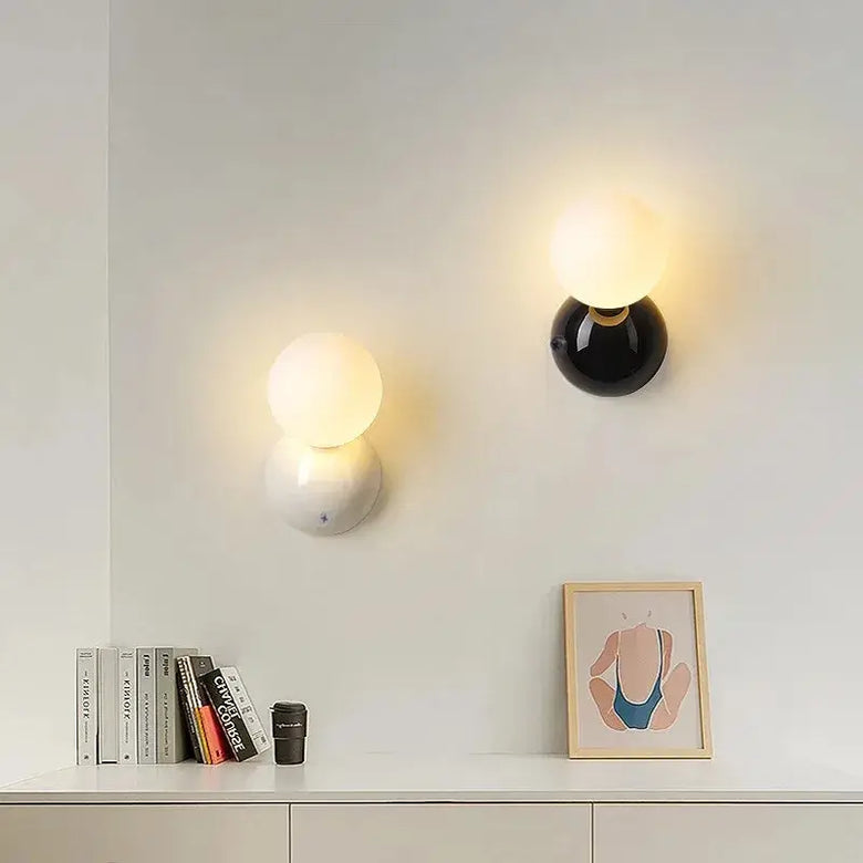 70s revival wall lamp in 3 different colours mounted on a wall with frosted glass ball and painted metal base.