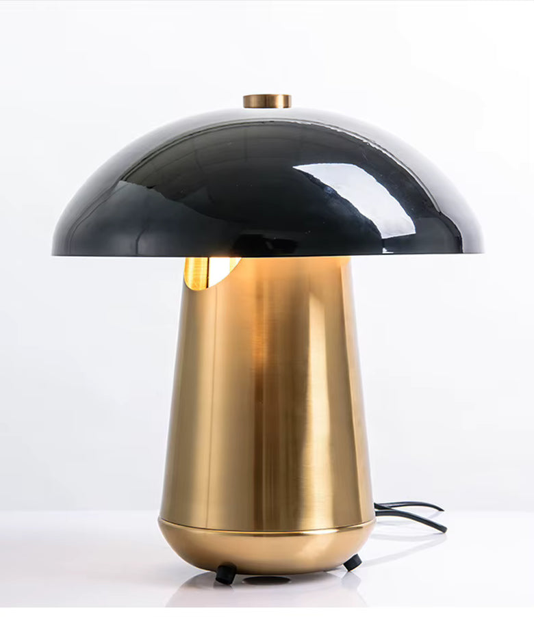 Hero A mushroom-shaped table lamp with a glossy black dome shade and a brushed gold metallic base, shown on a clean white background.