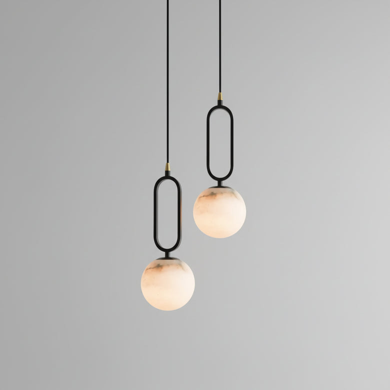 Hero - Two modern pendant lights with marble-like finishes hanging against a grey wall.