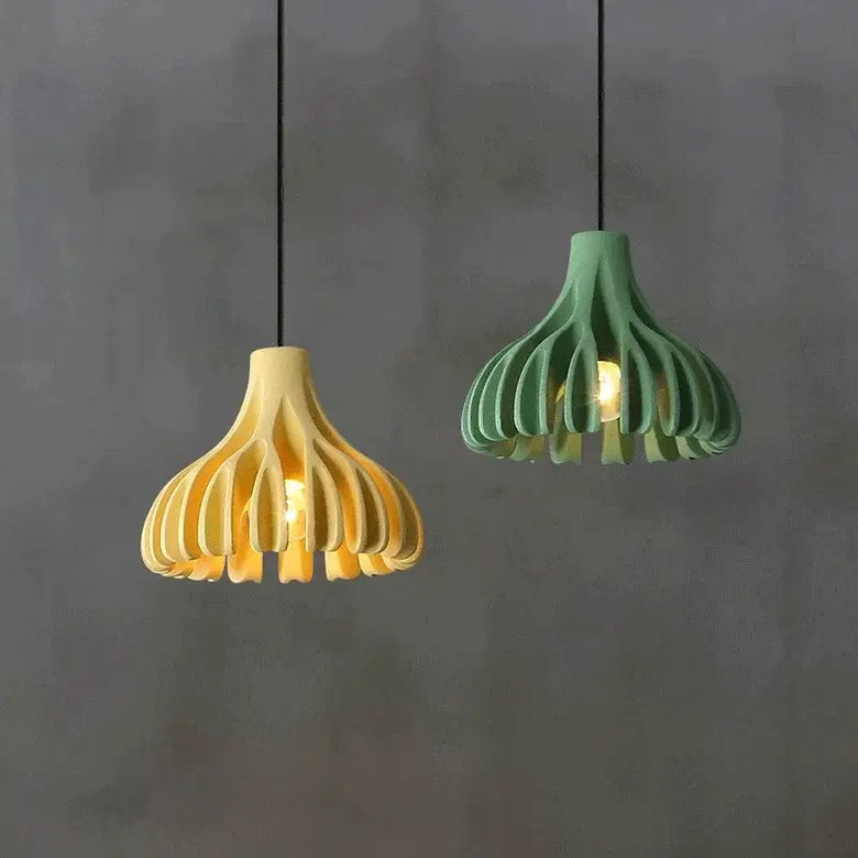 hero Two pendant lights, one yellow and one green, hanging against a gray background.