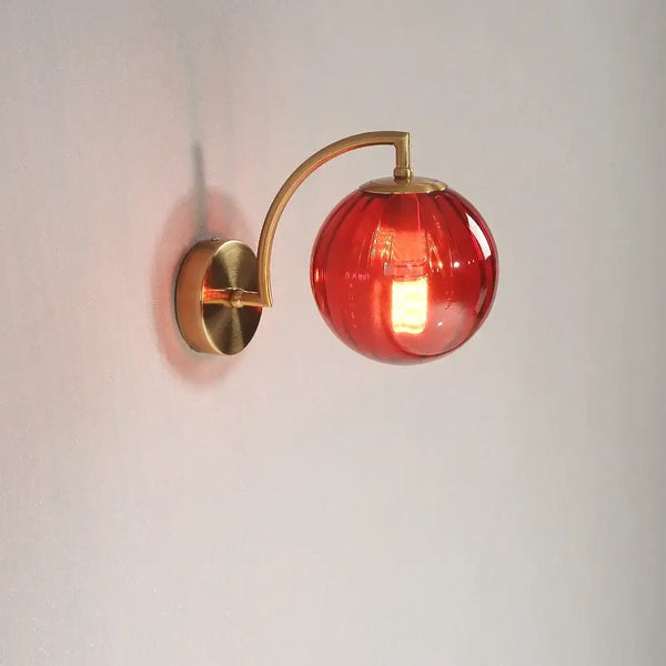 Colourful Glass Modern Wall Light with a golden base and a vibrant red bulb, perfect for modern decor.
