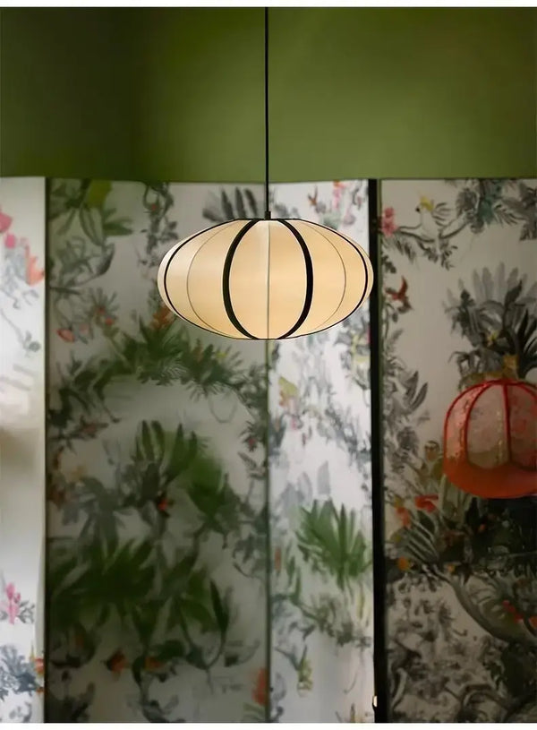 Zen Silk Pendant Light Mid Century Fabric Lantern hanging in a stylish room with botanical wallpaper.