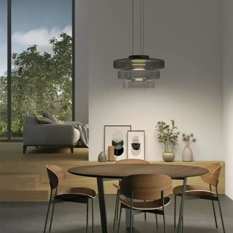 Layered Glass Pendant Light illuminating a modern dining area with stylish furnishings and a minimalist design.