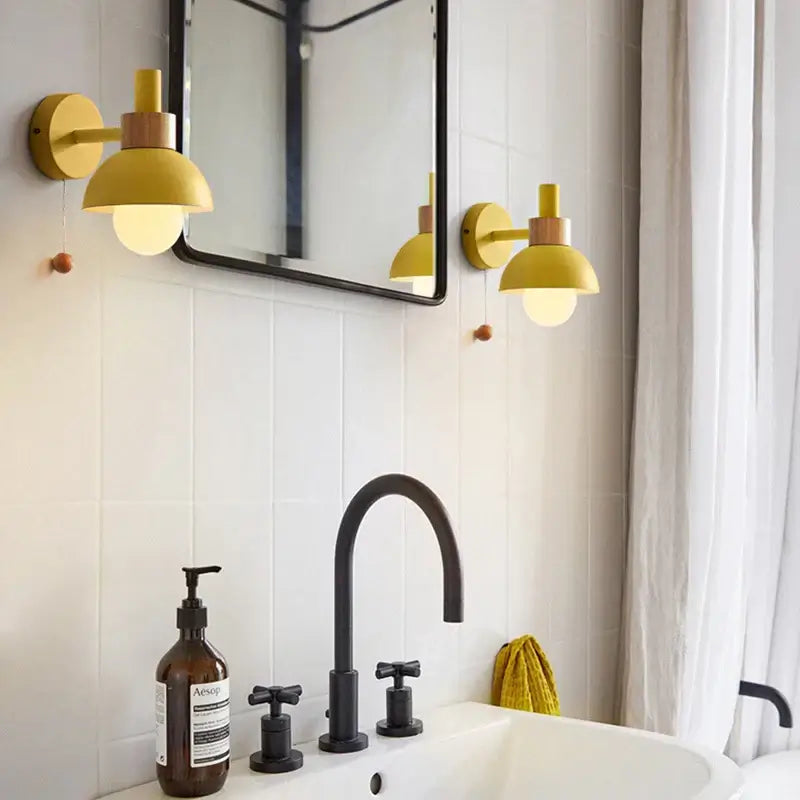 Pull Chain Nordic Sconce lighting in a modern bathroom featuring stylish gold sconces and a black faucet.