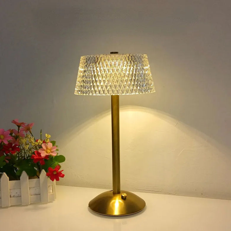 Hero Cordless table lamp with a crystal shade on a white surface next to flowers.