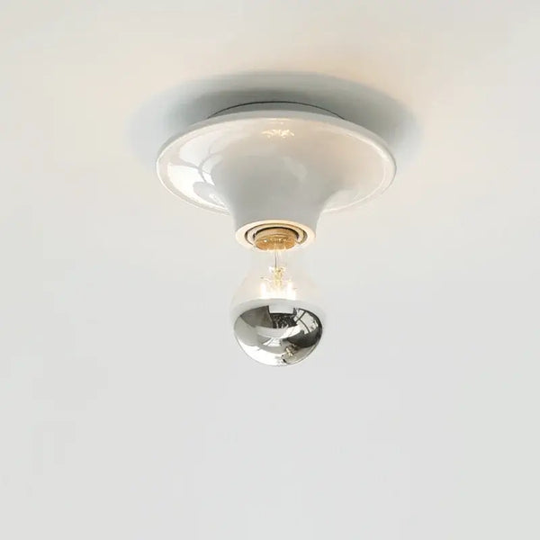 80s revival wall light with UFO-shaped base and silver top bulb, perfect for adding retro charm to modern interiors.