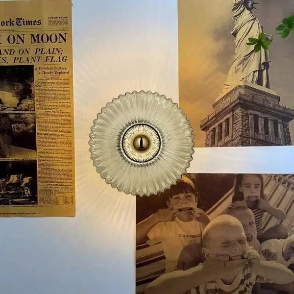 Radiant Modern Glass Wall Lamp illuminating vintage-style wall with newspaper and historical images.