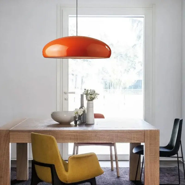 Simple Hanging Lamp in modern dining area with orange shade and wooden table.