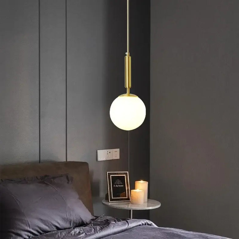 Mid-Century Modern Glass Ball Pendant Light hanging in a stylish bedroom setting with soft lighting.