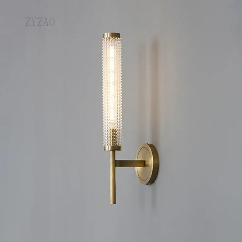 Stylish Art Deco Brass Wall Lamp with frosted glass and warm illumination on a wall.
