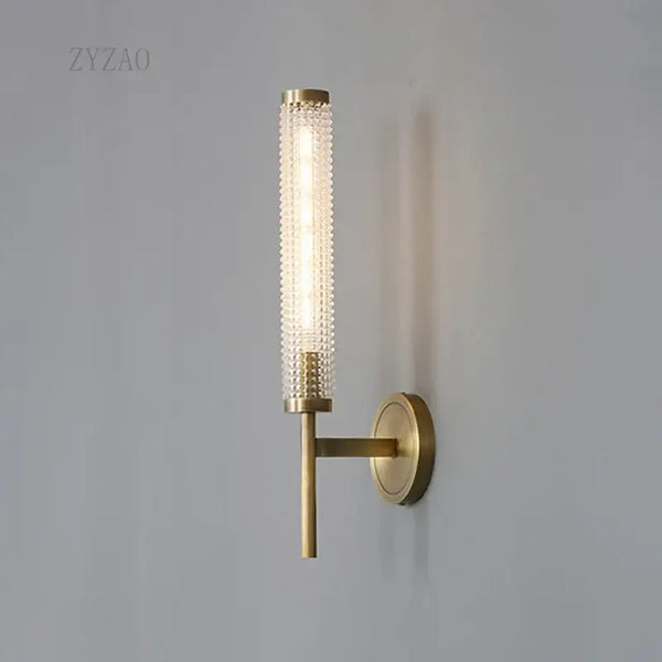 Stylish Art Deco Brass Wall Lamp with frosted glass and warm illumination on a wall.