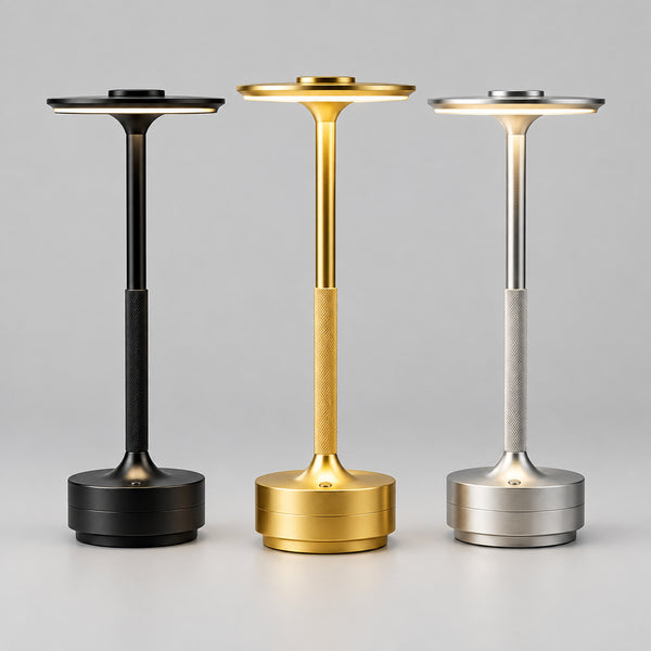 Art Deco cordless disc table lamps in black, gold and silver on a white desk