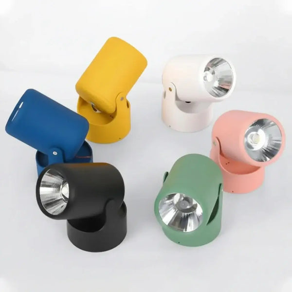 hero Six modern adjustable spotlight lamps in different colors (blue, yellow, white, pink, green, and black) arranged on a light gray background.