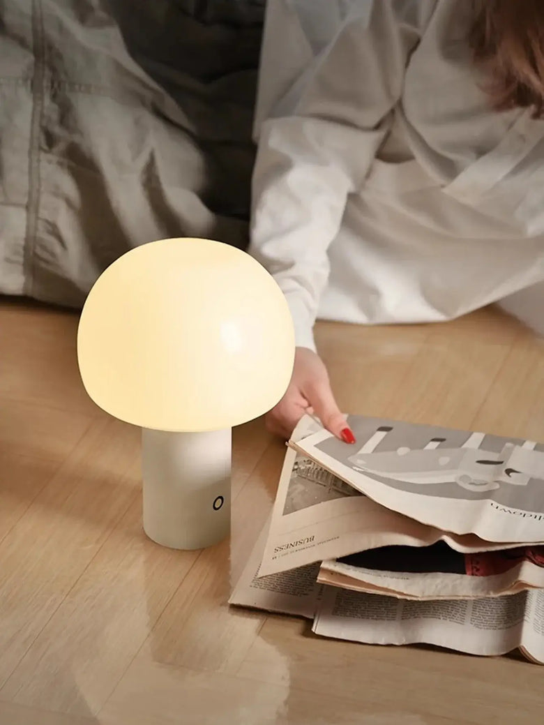 Modern Mushroom LED Table Lamp – Rechargeable & Portable Light illuminating a cozy living space while a person reads.