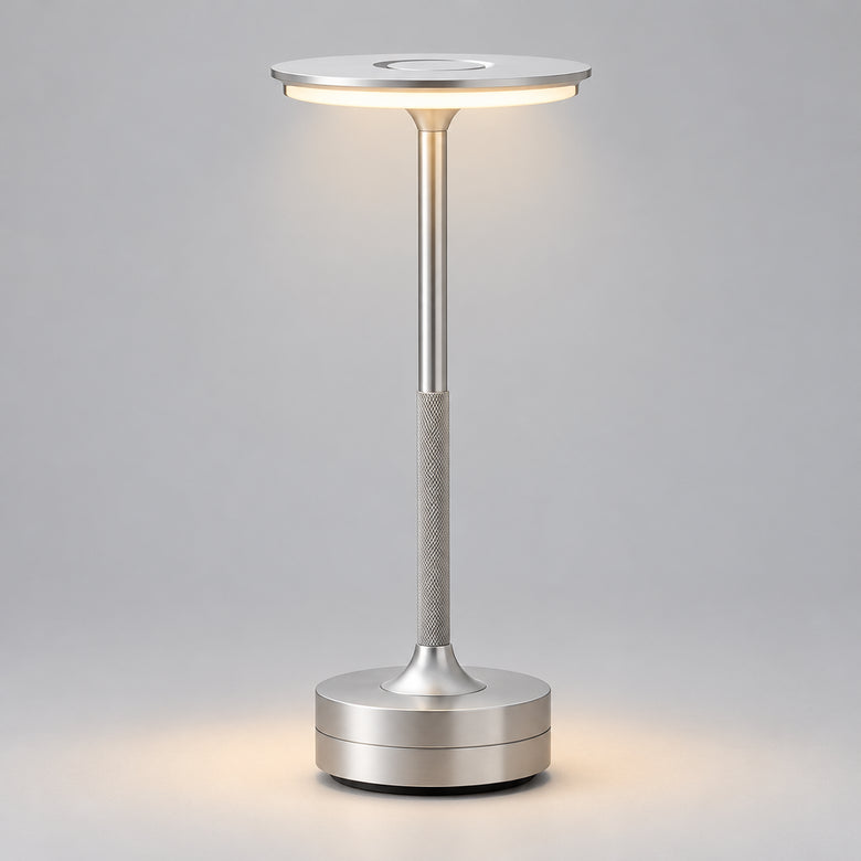 Silver Art Deco cordless disc table lamp on a wooden table