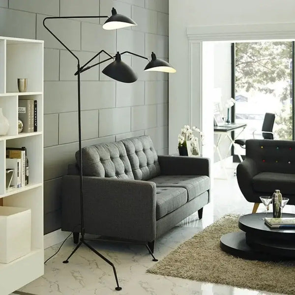 Nordic Designer Tripod Floor Lamp illuminating a modern living room with gray sofa and stylish decor.