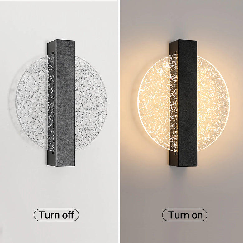 A wall-mounted rectangular light fixture shown in a split comparison: left side labeled 'Turn off' shows the light off with a clear circular shade and dark central bar; right side labeled 'Turn on' shows the light on with warm white illumination and the same clear circular shade.