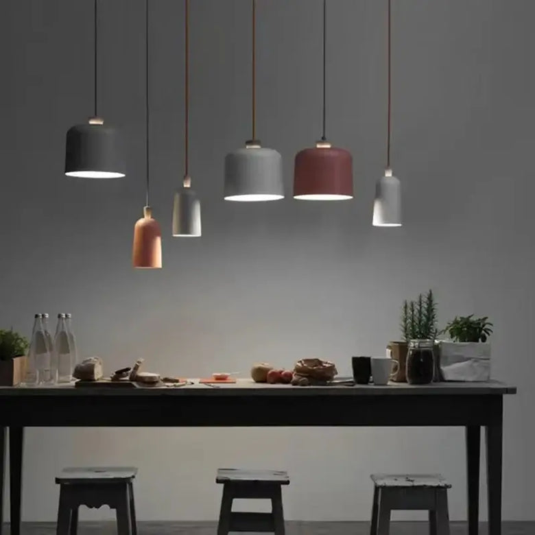 Colourful, modern, metal Danish Light Pendant illuminating a dining table with minimalist decor.