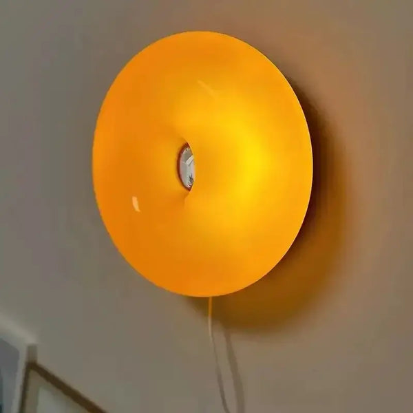 Glass Donut Wall Lamp featuring warm orange glow, enhancing ambiance in any intimate space.