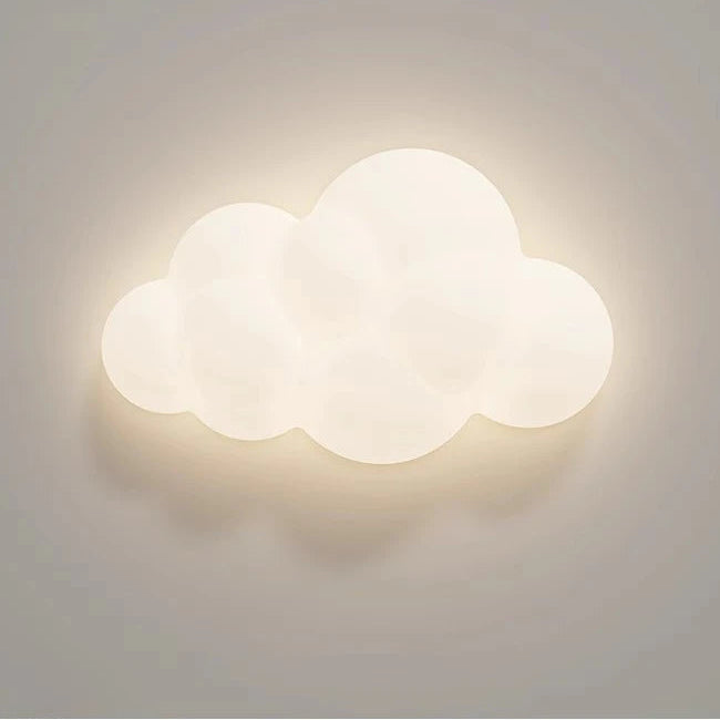 Hero A cloud-shaped wall light fixture with a warm white glow, mounted on a neutral gray wall.