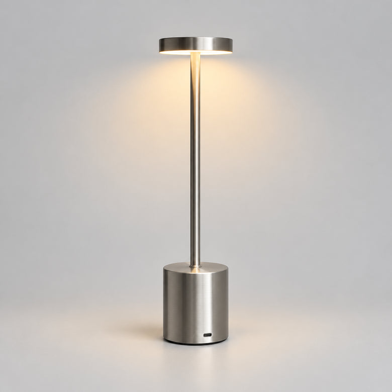 Hero - Modern Silver Cordless Table lamp, with light on, on grey background.