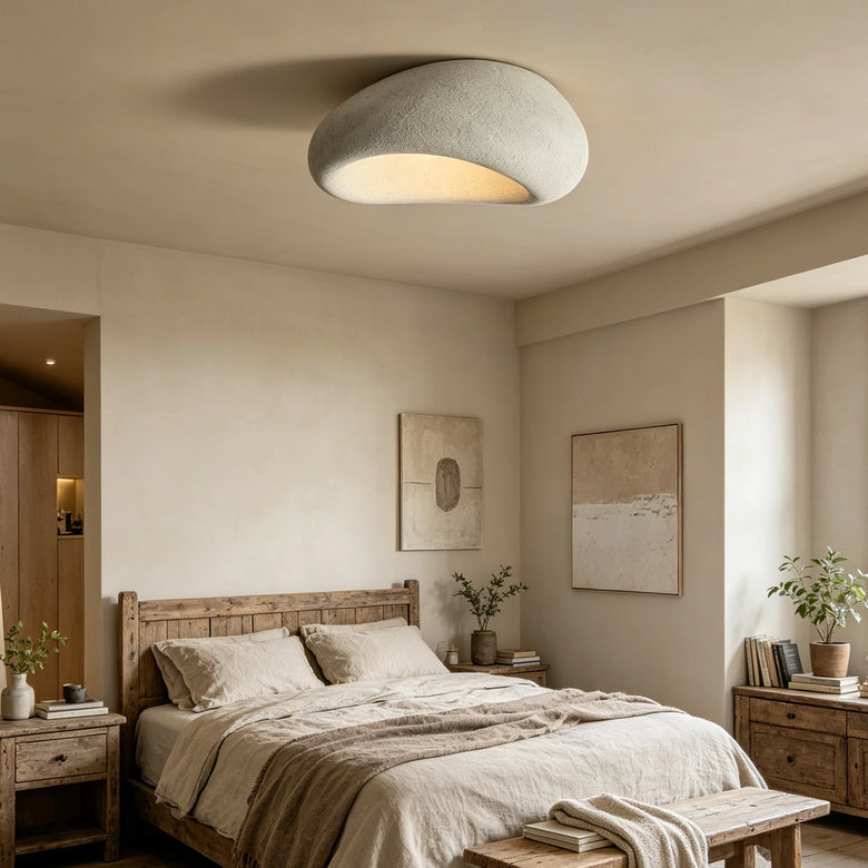 Organic stone ceiling light grey white illuminating a cozy bedroom with wooden furniture.
