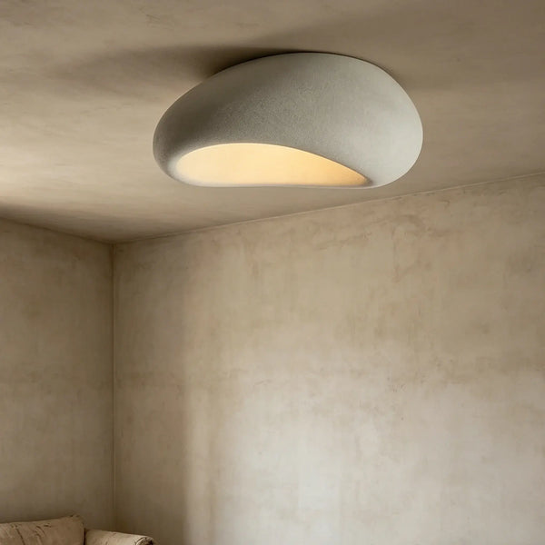 Organic stone ceiling light grey white illuminating a modern interior with a soft, sculptural design.