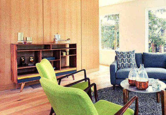 The use of color in Mid-Century Modern living room with green chairs and wooden furnishings