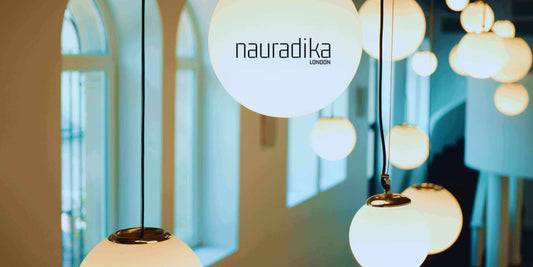 Hanging white lamps in a stylish interior setting by Nauradika London, illustrating mixing patterns in interior design.