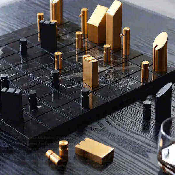 Modern chess set highlighting why is chess so popular in home decor, with sleek black and gold pieces on a textured board.