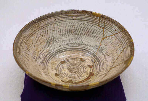 Kintsugi: The Wabi-Sabi Art of Japanese Ceramic Repair showcasing a repaired ceramic bowl with golden joinery lines.