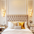 Pair of art deco crystal wall lights either side of an upholstered bed in an elegant bedroom