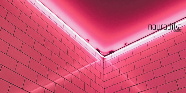 Monochromatic Lighting Ideas: Pink neon lights illuminating a modern tiled corner wall